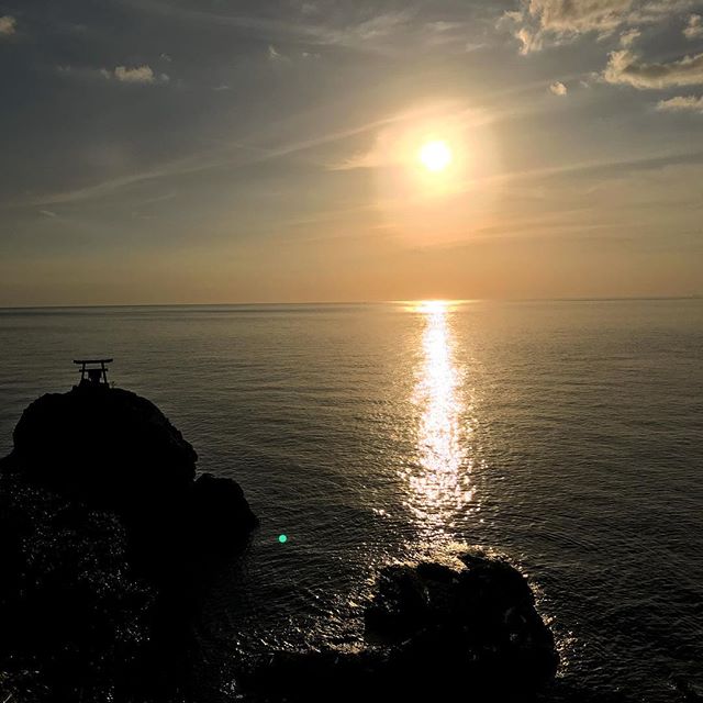 海に沈む夕陽と網掛岩